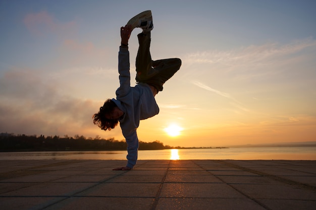 Free photo full shot man silhouette jumping at sunset