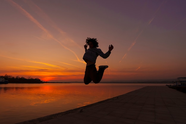Full shot man silhouette jumping at sunset