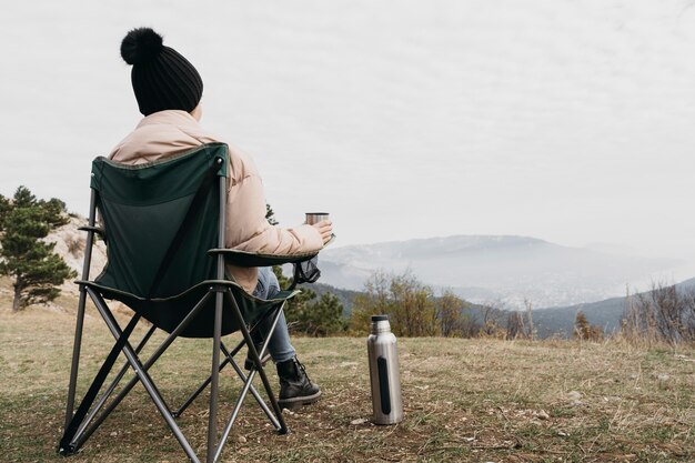 Full shot man sitting on chair outdoors