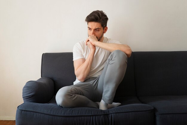 Full shot man sitting on couch