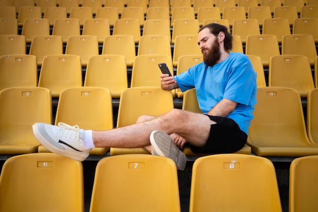 Full shot man sitting on grandstands