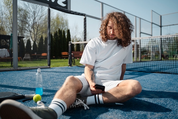 Free photo full shot man sitting on ground