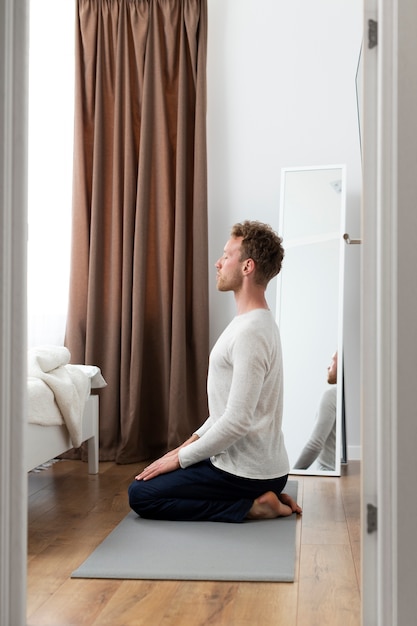 Full shot man sitting on mat