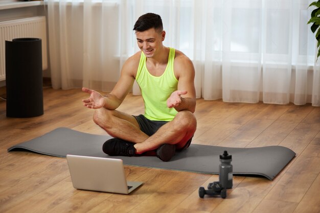 Full shot man sitting on mat