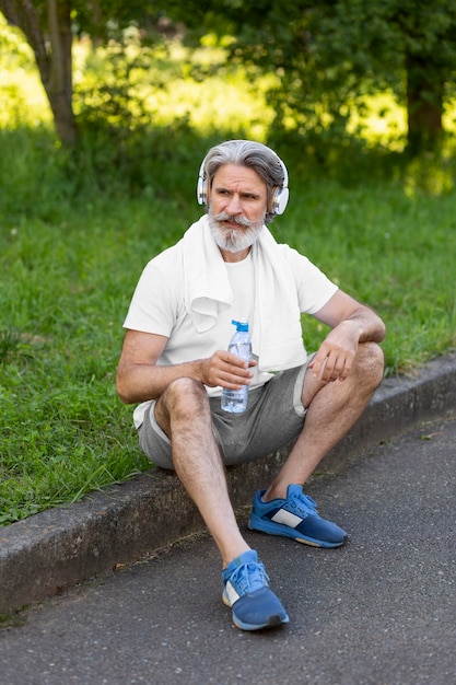 Free photo full shot man sitting outdoors