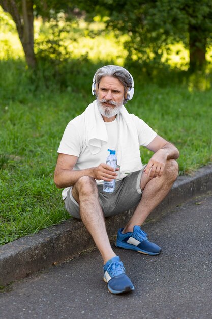 Full shot man sitting outdoors