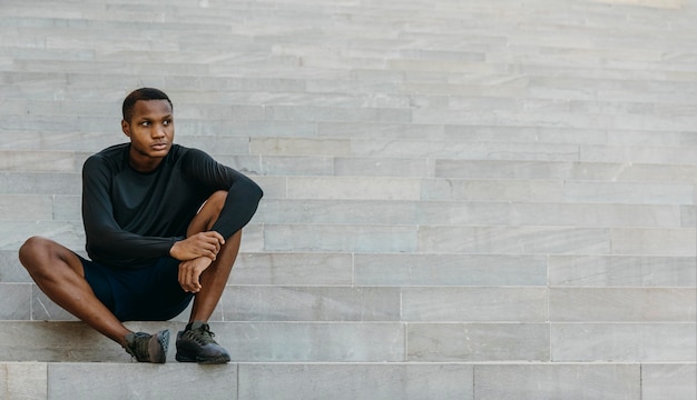 Free photo full shot man sitting on stairs