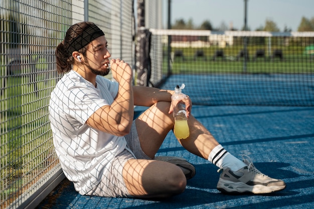 Full shot man sitting with drink