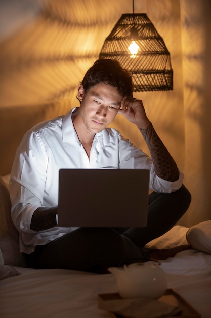 Full shot man sitting with laptop