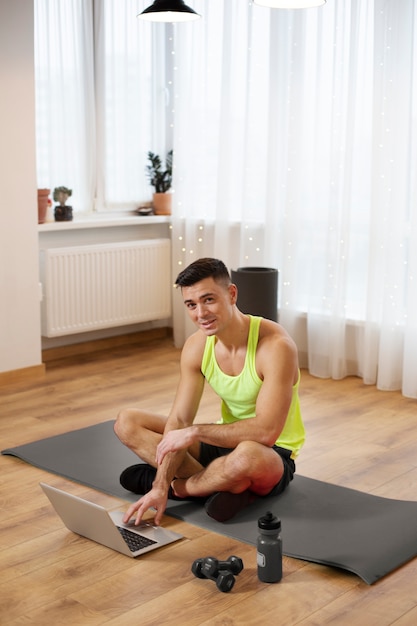 Free photo full shot man sitting on yoga mat