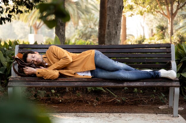 Full shot man sleeping on bench