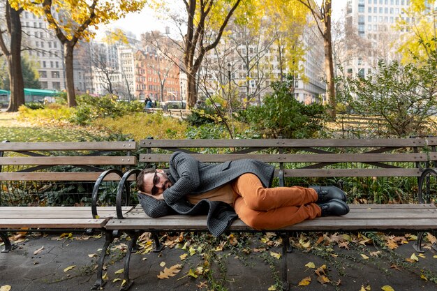 公園で寝ているフルショットの男