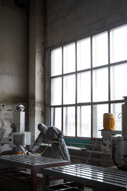 full shot man spraying powder paint from a gun