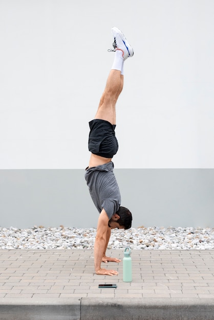 Full shot man standing on hands