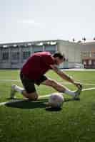 Free photo full shot man stretching on field