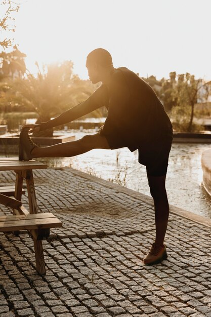 Full shot man stretching his leg