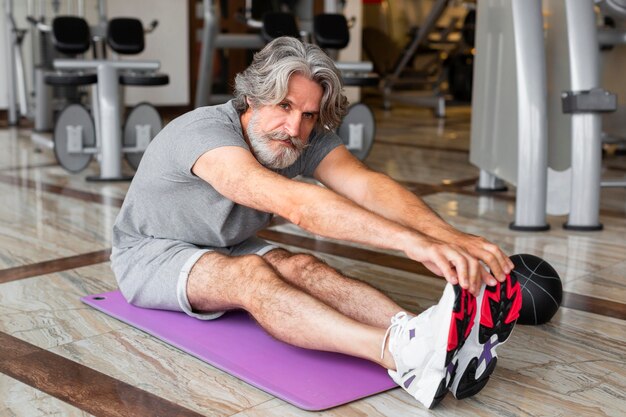 Full shot man stretching indoors