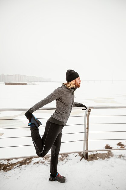 Full shot man stretching leg