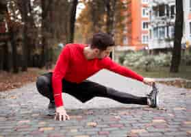 Free photo full shot man stretching outdoors