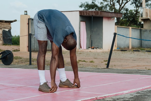 Full shot man stretching outdoors