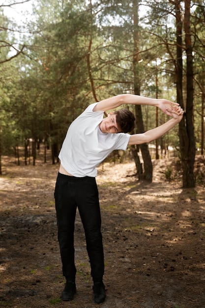 Free photo full shot man stretching outdoors