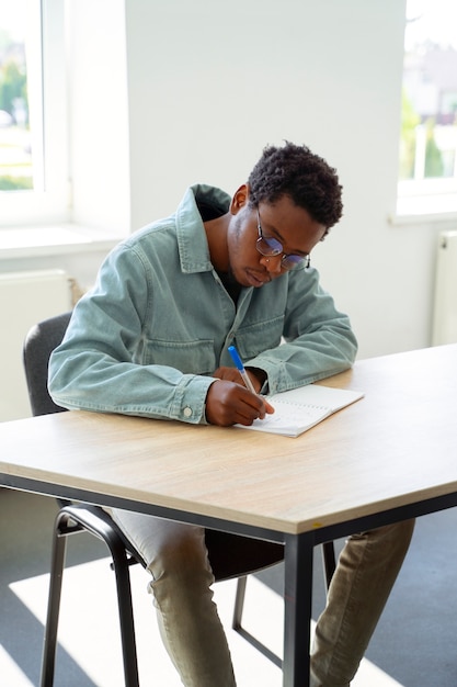 Free photo full shot man studying in classroom