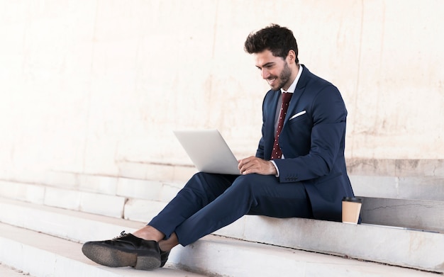 Full shot man in suit working on stairs