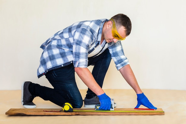 Free photo full shot of man taking measure on wood