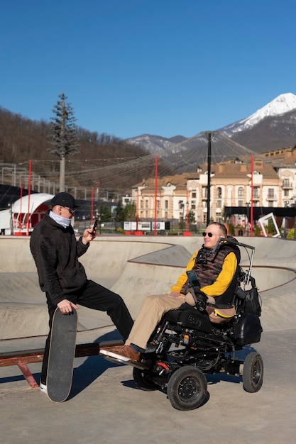 Full shot man taking photos of disabled friend