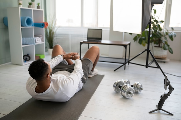 Бесплатное фото Тренировка человека в полный рост на коврике для йоги
