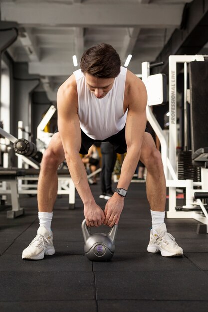 Full shot man training with kettlebell at gym