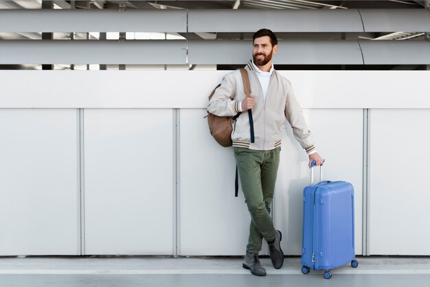 手荷物を持って旅行するフルショットの男