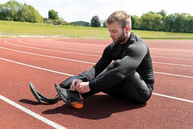 Full shot man tying shoelaces