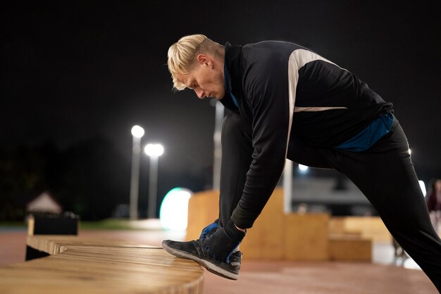 Full shot man tying shoelaces