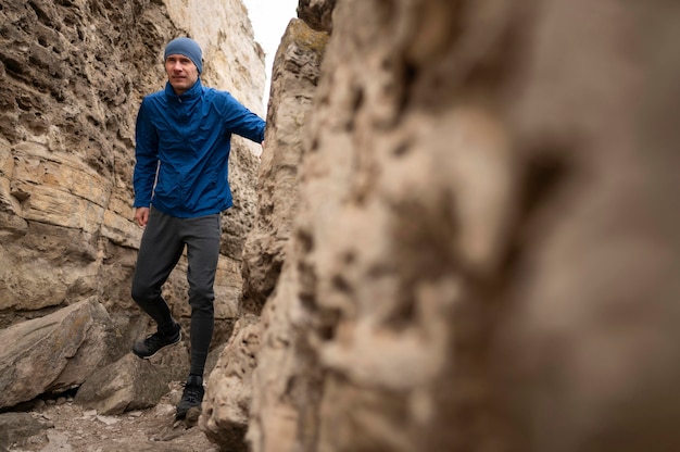 Full shot man walking through rocks