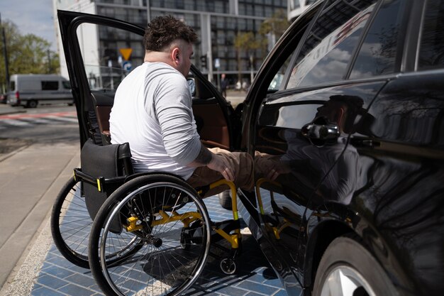Full shot man in wheelchair getting inside car