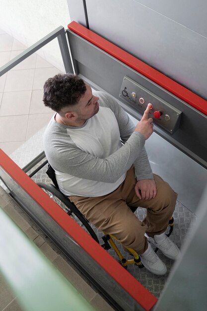 Full shot man in wheelchair using elevator