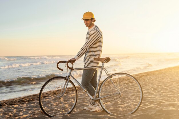 Full shot man with bicycle at seaside