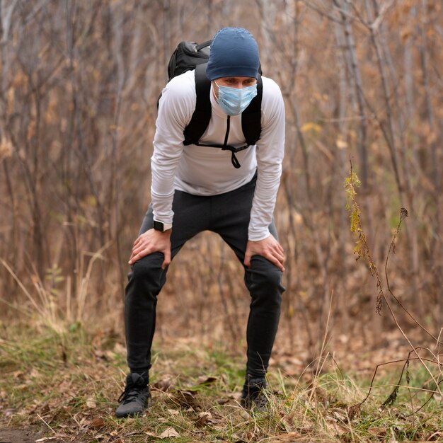 Full shot man with face mask in the woods