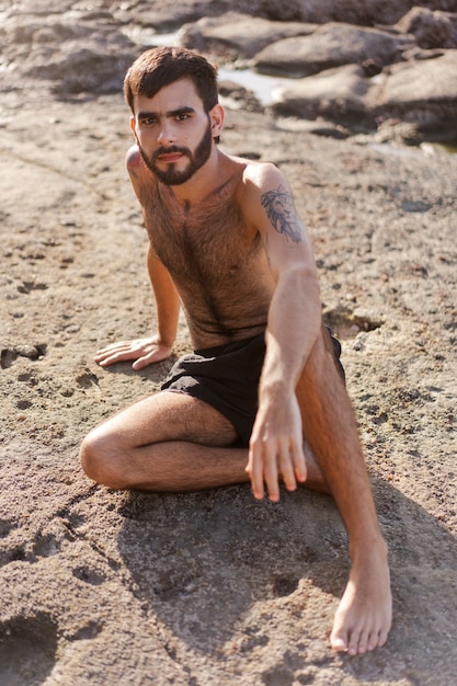 Free photo full shot man with hairy chest at seaside