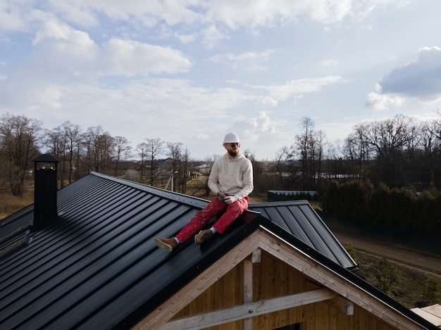 Full shot man with helmet sitting on roof