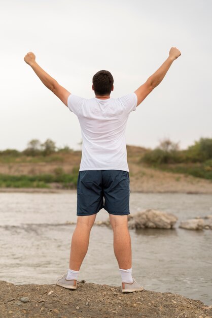 Full shot of a man with his arms in the air