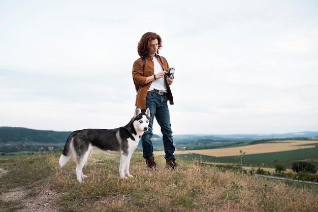 Full shot man with husky outdoors