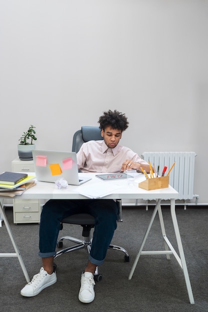 Full shot man with laptop and tablet