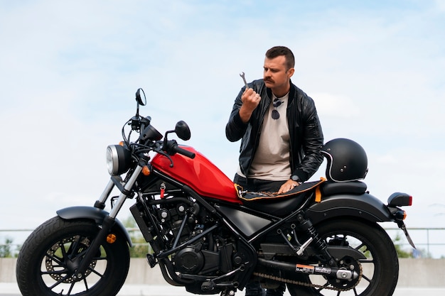 Full shot man with motorbike outdoors