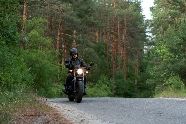 Full shot man with motorbike outdoors