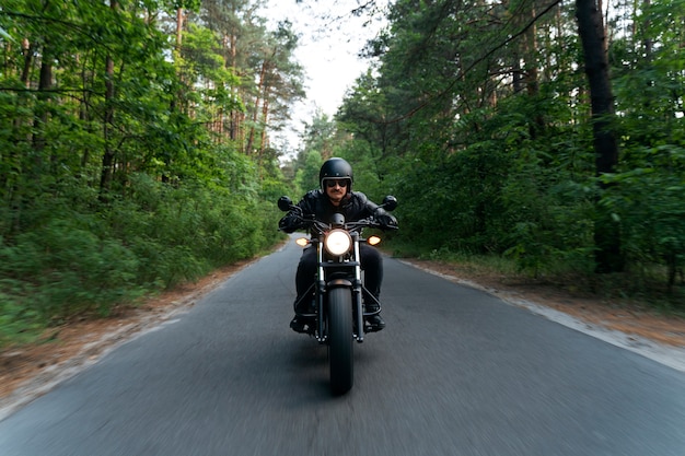 Бесплатное фото Полный человек с мотоциклом на открытом воздухе