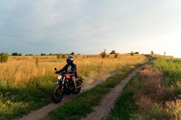 Full shot man with motorbike outdoors