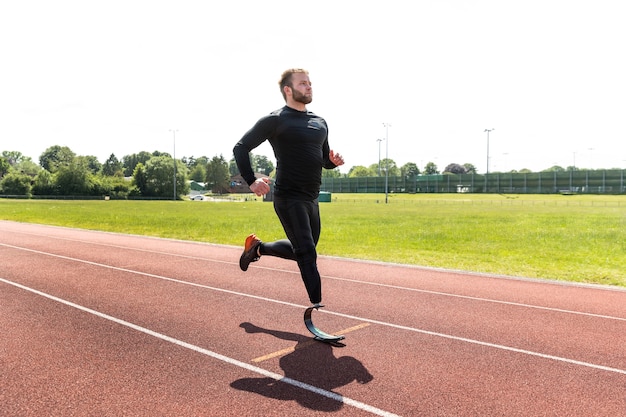 Free photo full shot man with prosthesis running