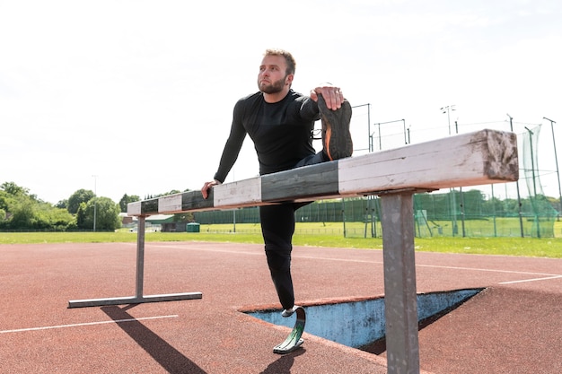 Full shot man with prosthesis stretching